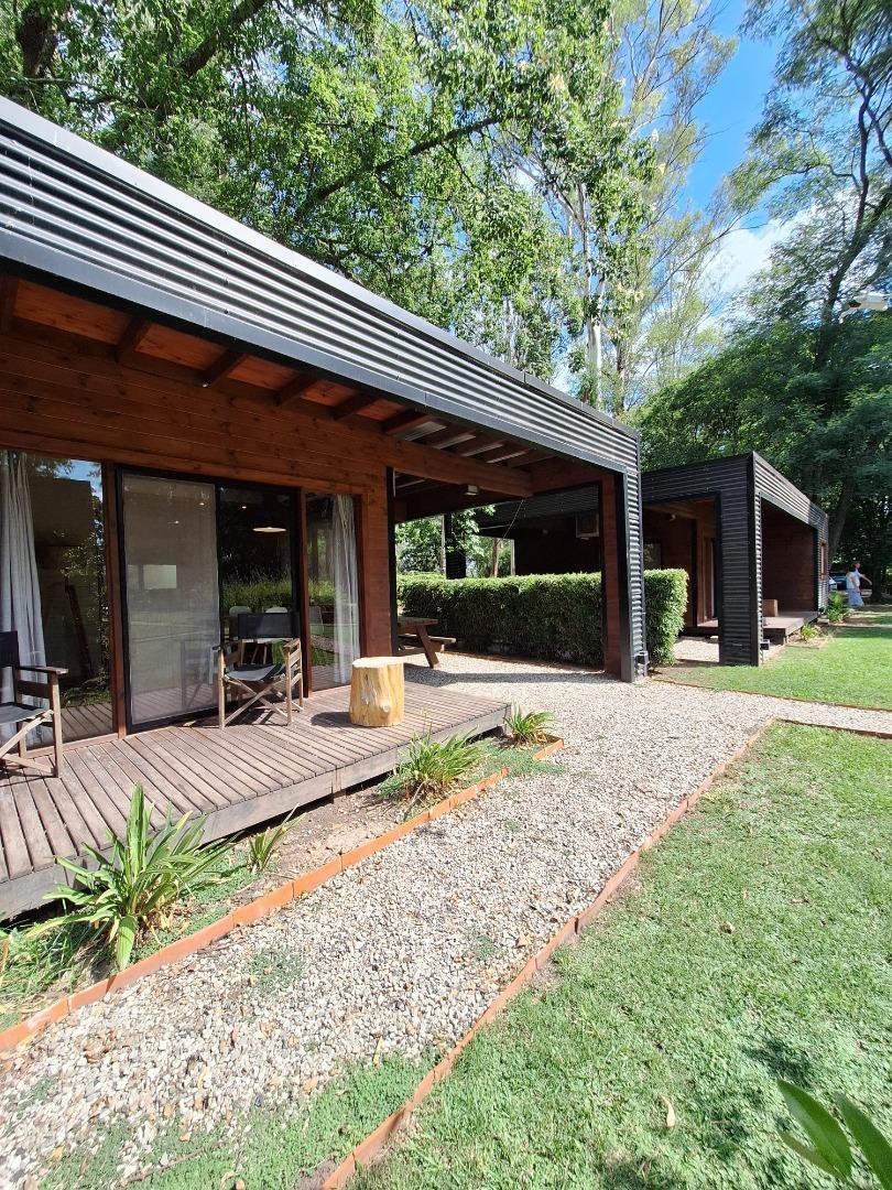 MEDIA HECTAREA EN OLIVEROS CON CONJUNTO DE CABAÑAS Y PILETA